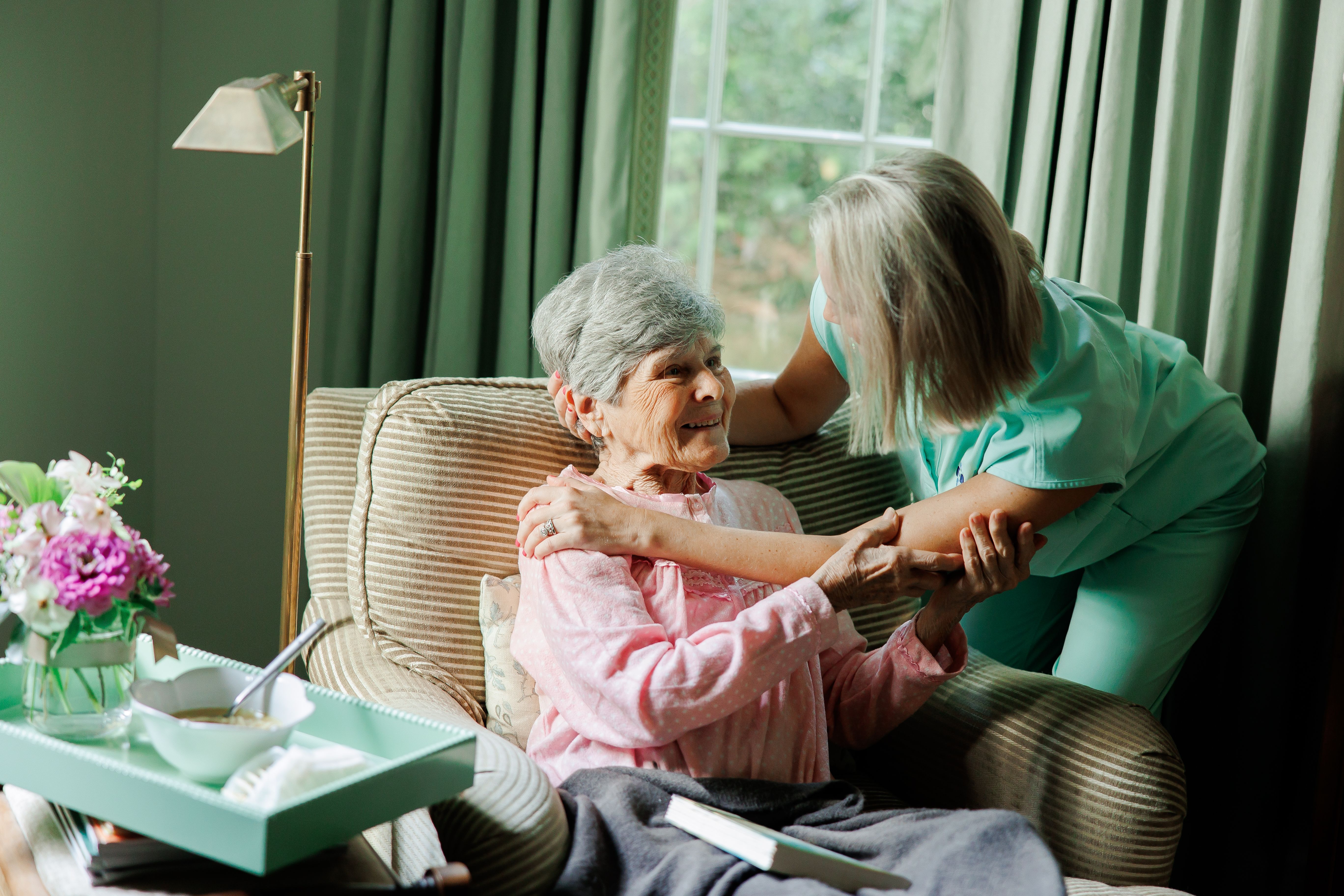 Caregiver sharing a reassuring moment with a senior woman at home